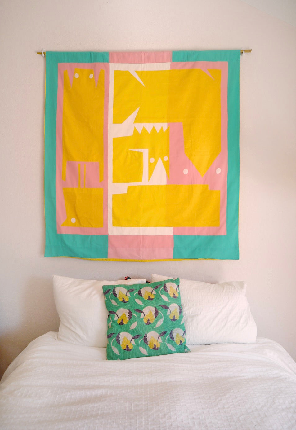 The flag is hanging on a wall above a bed.